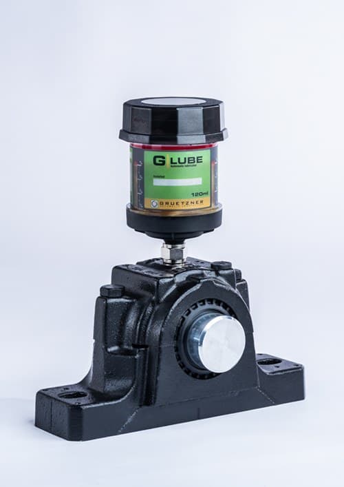 Lubricador automático Gruetzner G-LUBE instalado sobre una chumacera industrial